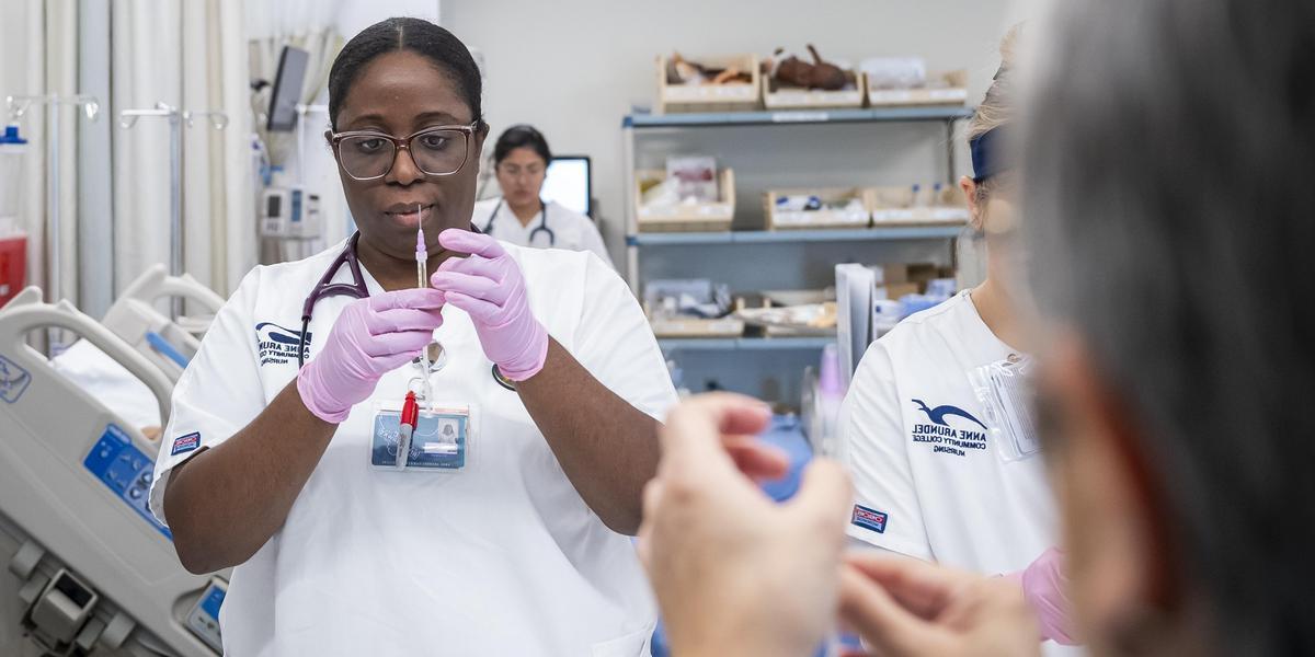 Nursing student working with a needle.